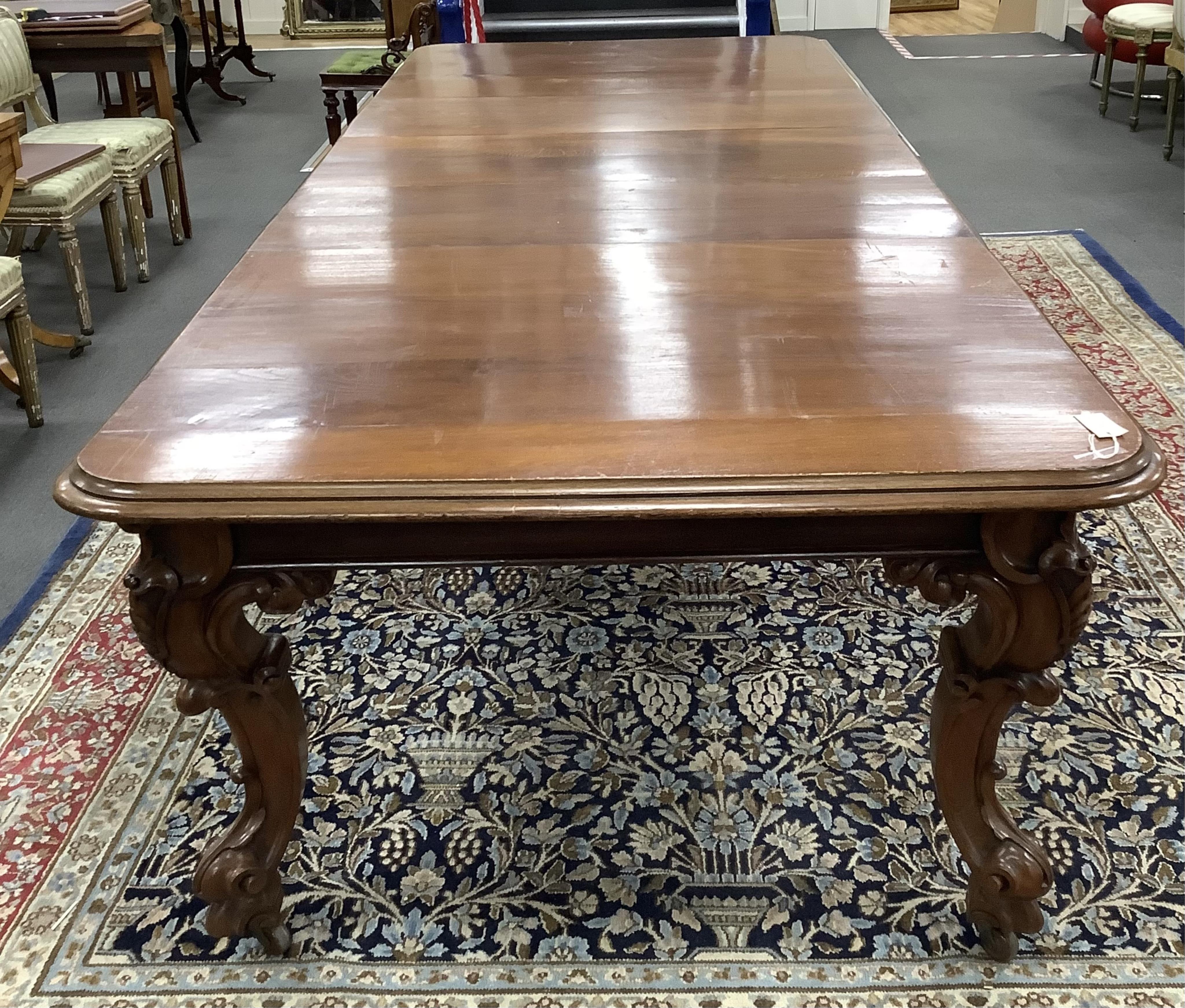 A Victorian oak extending dining table on carved cabriole legs, width 320cm extended, three spare leaves, depth 128cm, height 77cm. Condition - fair